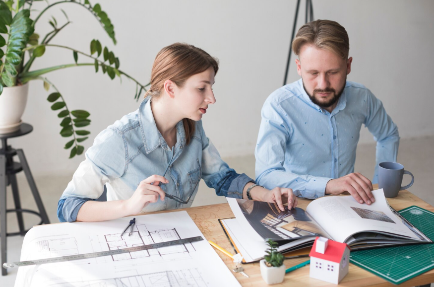 homeowners reviewing renovation plans with a designer when deciding to hire a designer vs design-build firm