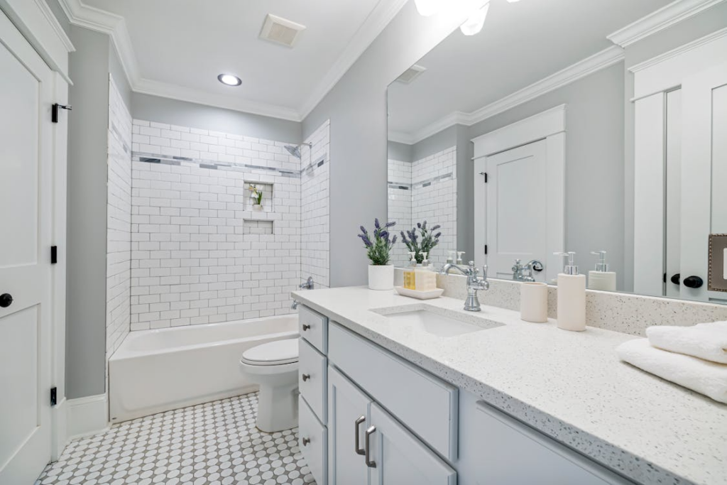 Bathroom renovation services in a bright, updated bathroom with tile surround and new vanity.