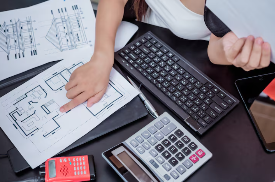 Home renovation cost planning with blueprints and calculator on desk
