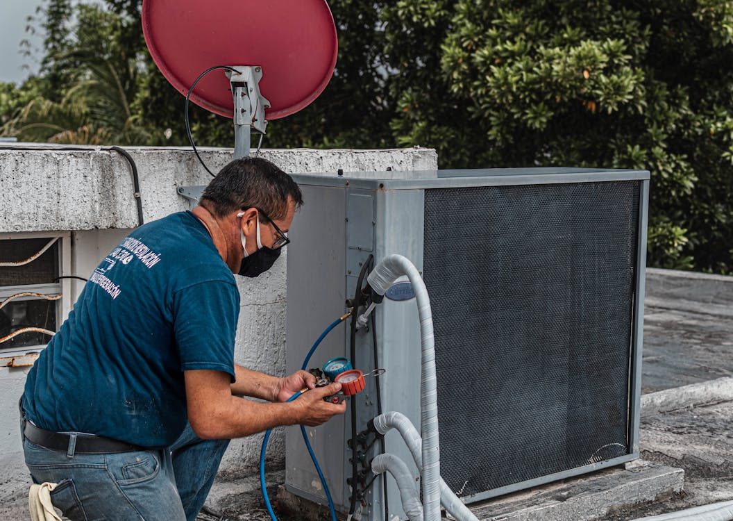 Technician inspecting outdoor unit during HVAC replacement planning guide evaluation