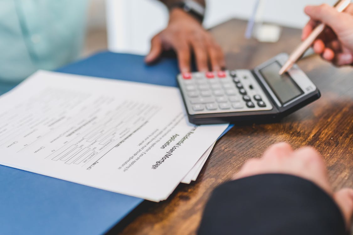 Homeowner calculating renovation payment schedule while reviewing contract documents